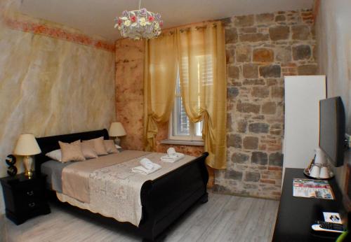 a bedroom with a bed and a brick wall at Pietra Rossa in Split