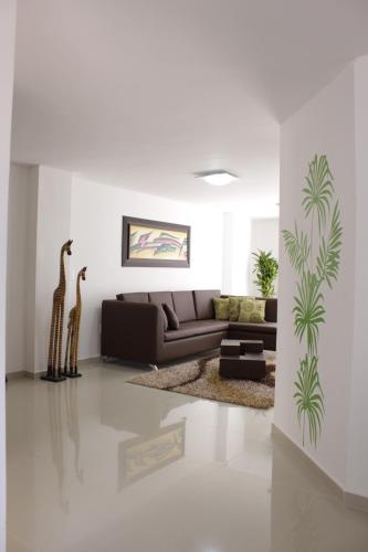 a living room with a brown couch and a giraffe at Hotel Buena Vista in Bucaramanga