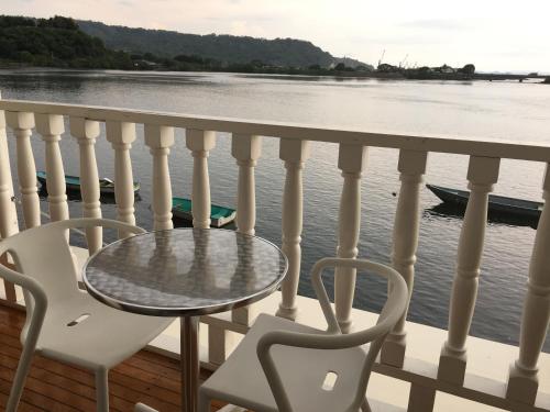 a table and chairs on a balcony overlooking the water at Hotel y Restaurante Costa del Sol in Mata de Limón