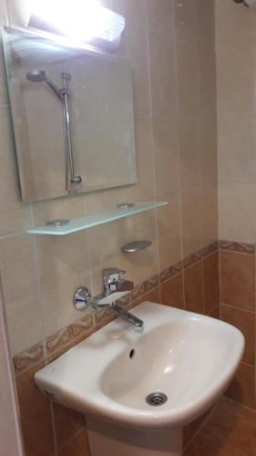 ein weißes Waschbecken in einem Badezimmer mit einem Spiegel in der Unterkunft Apartament Bogoridi in Burgas City