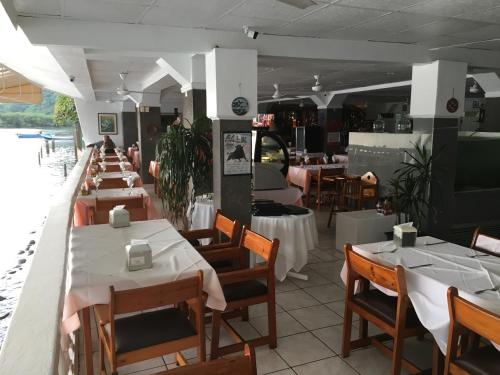 a dining room with tables and chairs in a restaurant at Hotel y Restaurante Costa del Sol in Mata de Limón