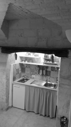 a kitchen with a sink and a counter top at Dimora Miccolis in Alberobello
