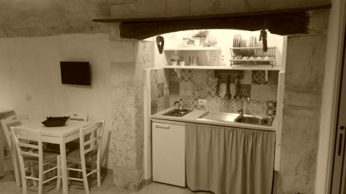 a small kitchen with a sink and a table at Dimora Miccolis in Alberobello