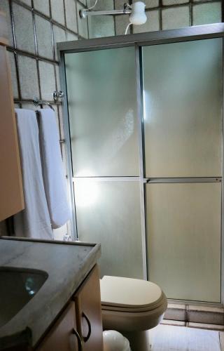 a bathroom with a shower with a toilet and a sink at Pousada Casa Grande in Bonito