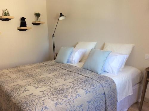 パラドゥーにあるLa Maison du Paradouのベッドルーム1室(白いシーツと青い枕のベッド1台付)