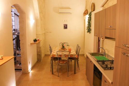 a kitchen with a table and chairs in a room at L'insula in Scicli