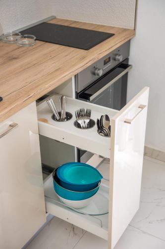 a kitchen counter with a blue bowl on a shelf at Apartments Villa Monique in Rogoznica