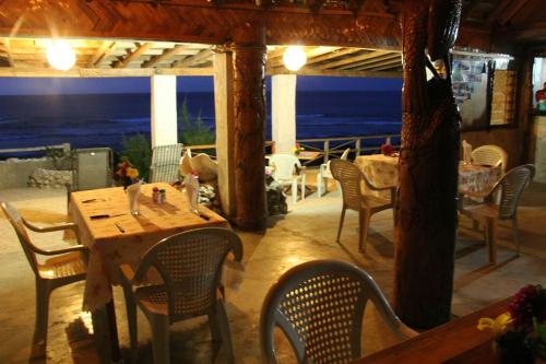 un restaurante con mesa y sillas y vistas al océano en Rocky Ridge Bungalows, en Tanna Island