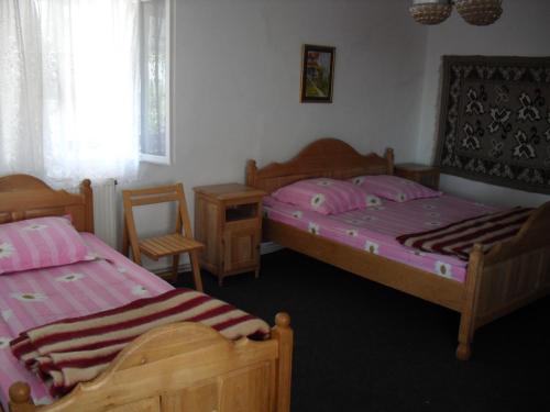 a bedroom with two beds and a table and chairs at Padurea De Argint in Văratec