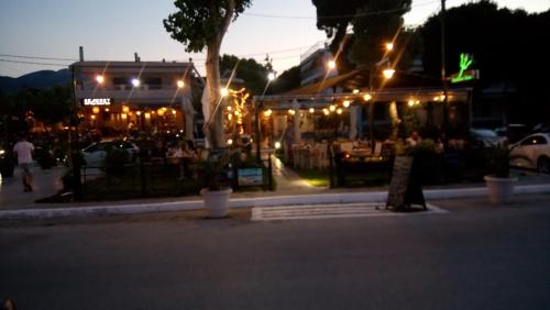 a restaurant with lights on a street at night at Villa George - Family Holidays in Nea Makri