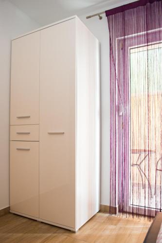 a white cabinet in a room with a window at Apartments Villa Monique in Rogoznica