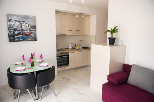 a kitchen with a table and chairs and a couch at Apartments Villa Monique in Rogoznica