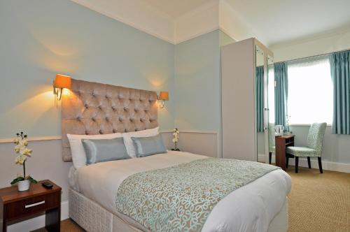 a bedroom with a large bed and a desk at Maples House Hotel in Dublin