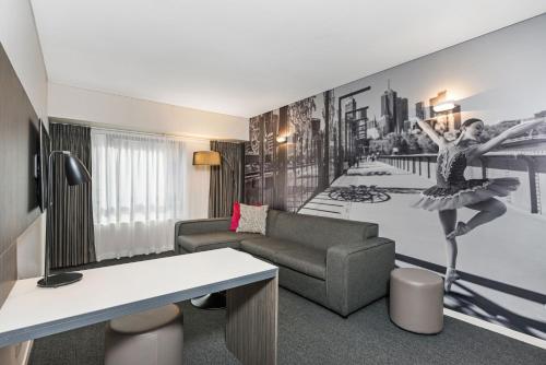 a living room with a couch and a dancer mural at Mantra Southbank in Melbourne
