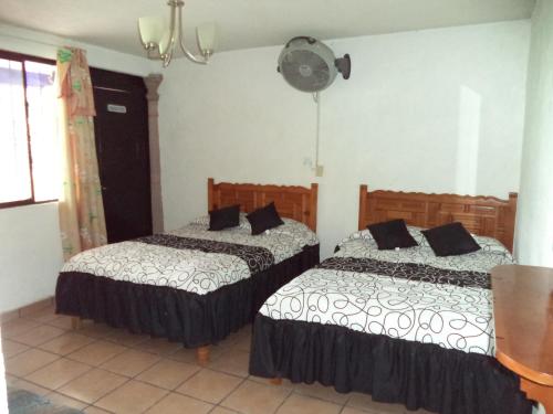 - une chambre avec 2 lits et un ventilateur mural dans l'établissement Hotel Ocampo, à Oaxtepec