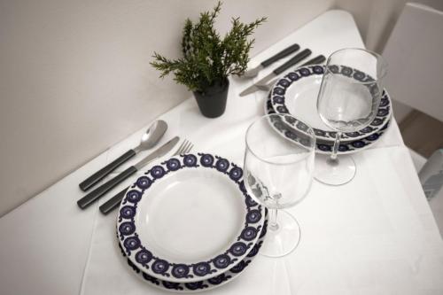 een witte tafel met twee borden en een wijnglas bij Apartment Charlie PERFECT PRICE in Belgrado