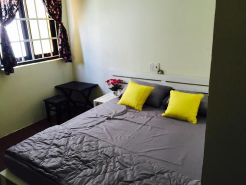a bedroom with a bed with two yellow pillows at Hotel An Nhien in Buon Ma Thuot