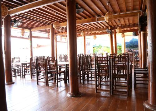 a room filled with wooden chairs and tables at Bac Ha Lake View in Bắc Hà