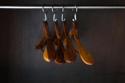 a group of woodenoons hanging on a rack at Diamond Park Inn Chiangrai & Resort in Chiang Rai