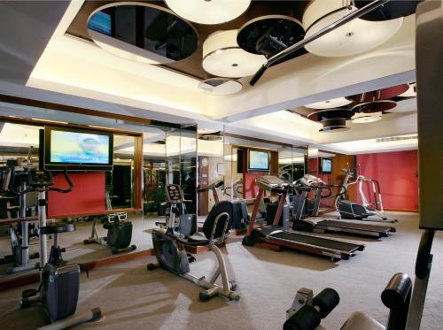a gym with treadmills and ellipticals and a television at Grand Noble Hotel Xi’an in Xi'an