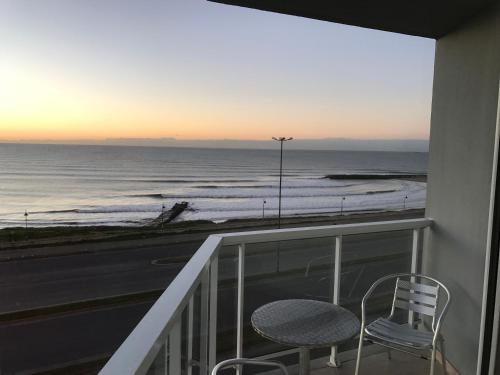 a balcony with a chair and a view of the ocean at Marco Polo Platinum Apartamento in Mar del Plata