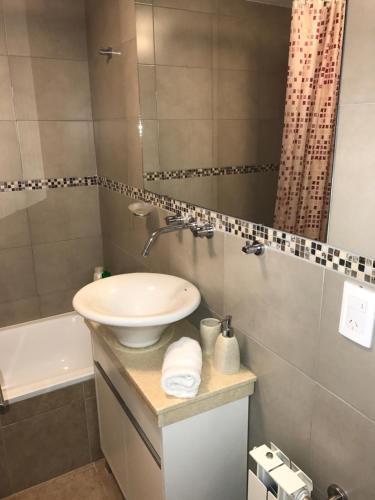 a bathroom with a sink and a mirror at Marco Polo Platinum Apartamento in Mar del Plata