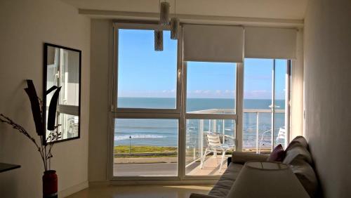 a living room with a large window with a view of the ocean at Marco Polo Platinum Apartamento in Mar del Plata