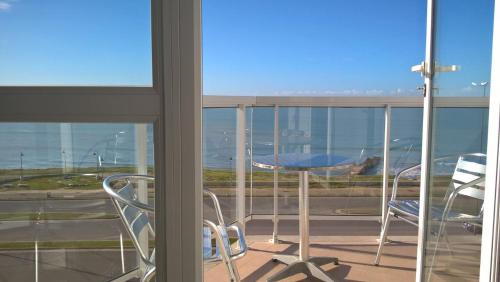 a balcony with two chairs and a view of an airport at Marco Polo Platinum Apartamento in Mar del Plata