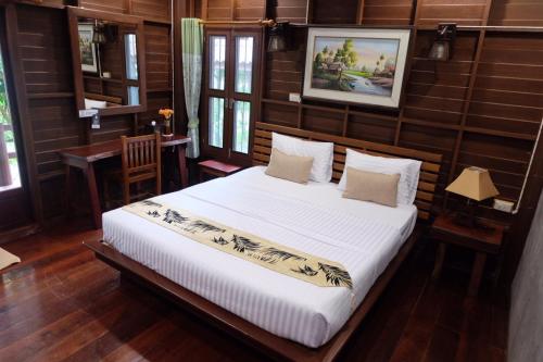 a bedroom with a large bed in a room with wooden walls at Ruenpurksa Resort in Prachuap Khiri Khan
