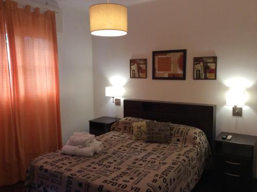 un dormitorio con una cama con un animal de peluche en Tiburcio en Mendoza