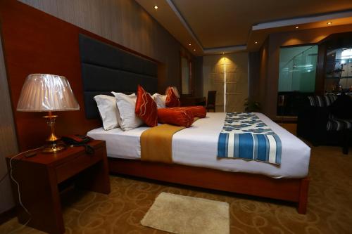 1 dormitorio con cama, lámpara y mesa en Peradeniya Rest House, en Kandy