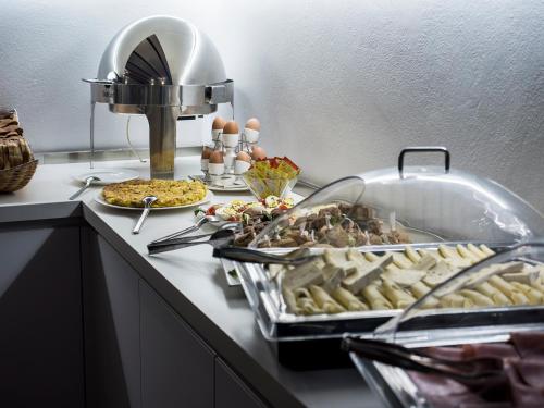 a buffet with a lot of food on a counter at Villa I Barronci Resort & Spa in San Casciano in Val di Pesa