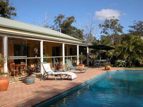 a house with a swimming pool in front of a house at Smoky Cape Retreat in South West Rocks
