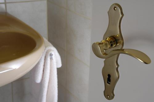 a brass faucet next to a sink in a bathroom at Casa Tödi Restaurant Hotel in Trun