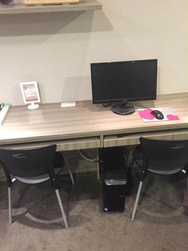 an office desk with a computer monitor and two chairs at Royal Hotel in Taipei