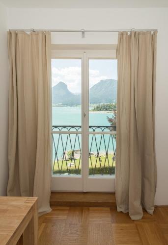 a room with a window with a view of the water at Seehaus Familie Leifer in St. Wolfgang