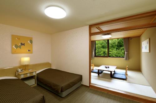 a hotel room with a bed and a window at Park Hotel Miyabitei in Noboribetsu