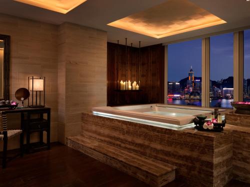 a bath tub in a room with a large window at The Peninsula Hong Kong in Hong Kong