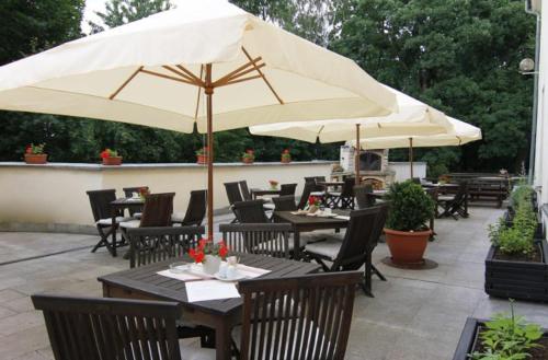 a patio with tables and chairs and an umbrella at Zámek Havířov in Havířov