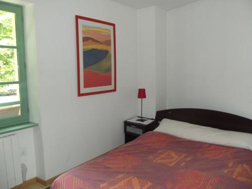 Un dormitorio con una cama y un cuadro en la pared. en allees des soupirs, en Cahors