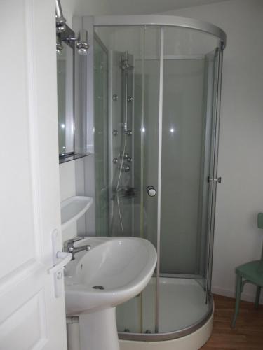 een badkamer met een glazen douche en een wastafel bij allees des soupirs in Cahors