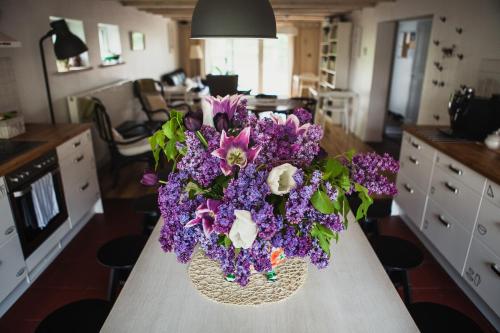 a vase of purple flowers sitting on a table at SAKÀ Vacation House in Druskininkai