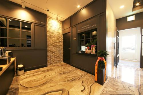 a lobby of a building with a door and a brick wall at Premium Ava Hotel in Busan