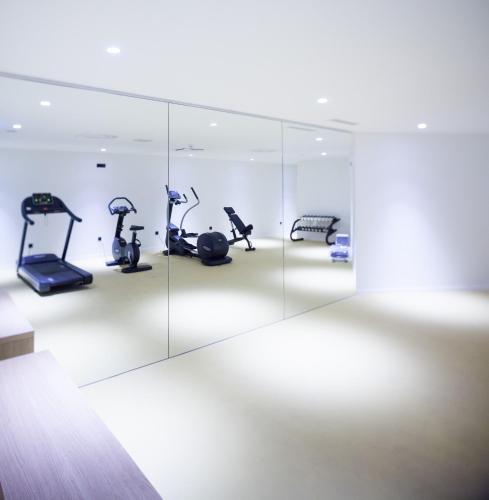 a gym with elliptical machines in a mirror at One Suite Hotel in Mlini