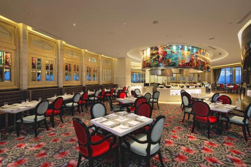 a restaurant with tables and chairs in a room at Hotel Ciputra World Surabaya managed by Swiss-Belhotel International in Surabaya