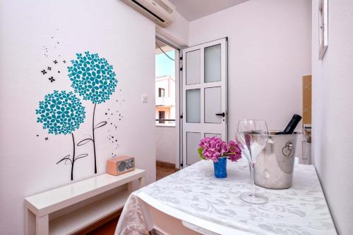 a dining room with a table with a vase of flowers at Anchor Apartments in Stari Grad