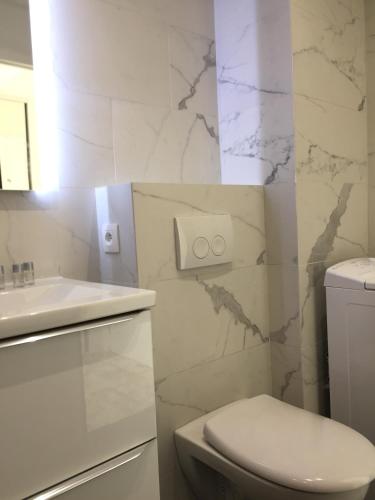 une salle de bain blanche avec des toilettes et un lavabo dans l'établissement Amazing Studio Cannes Center, à Cannes