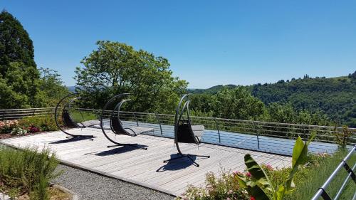a group of chairs on a wooden deck with a view at La Ferme du Cayla in Linac