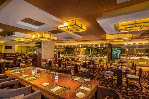 a restaurant with wooden tables and chairs and a bar at Soluxe Hotel Guangzhou - Overseas Buyers Registration Service&Canton Fair Free Shuttle Bus 15 Oct to 04 Nov in Guangzhou