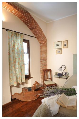 a living room with a bed and a window at Agriturismo Il Gioco Dell'Oca in Barolo